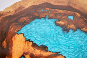 Round sliced walnut resin coffee table with unique cracks and holes inlays in turquoise colour